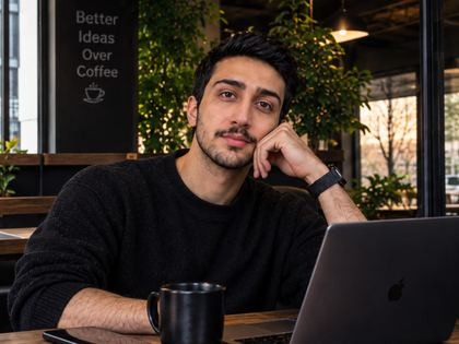 متین موفق با لپتاپ و یک فنجان قهوه در کافه